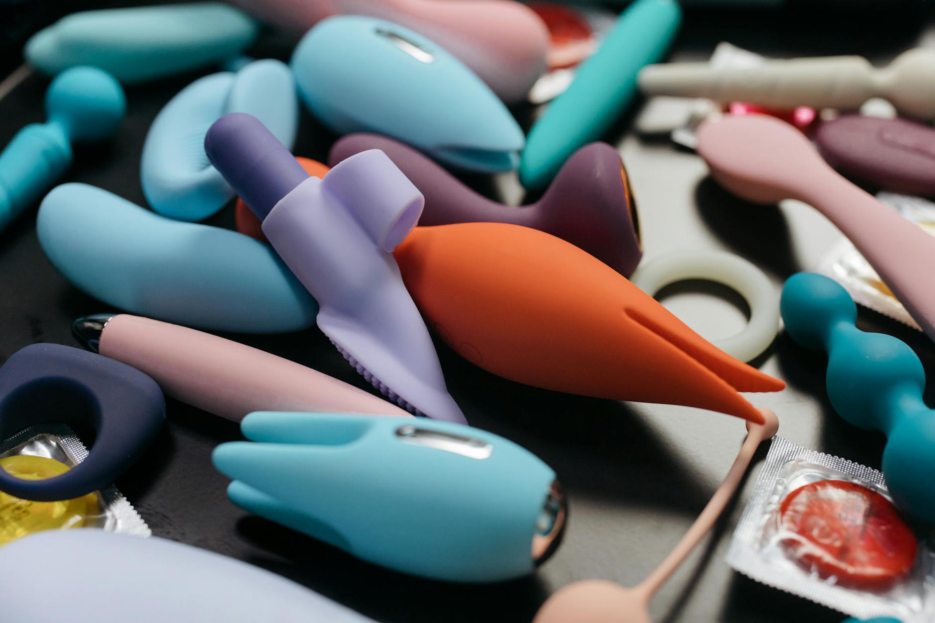 Woman holding blue and pink silicone vibrators with confidence and calm presence
