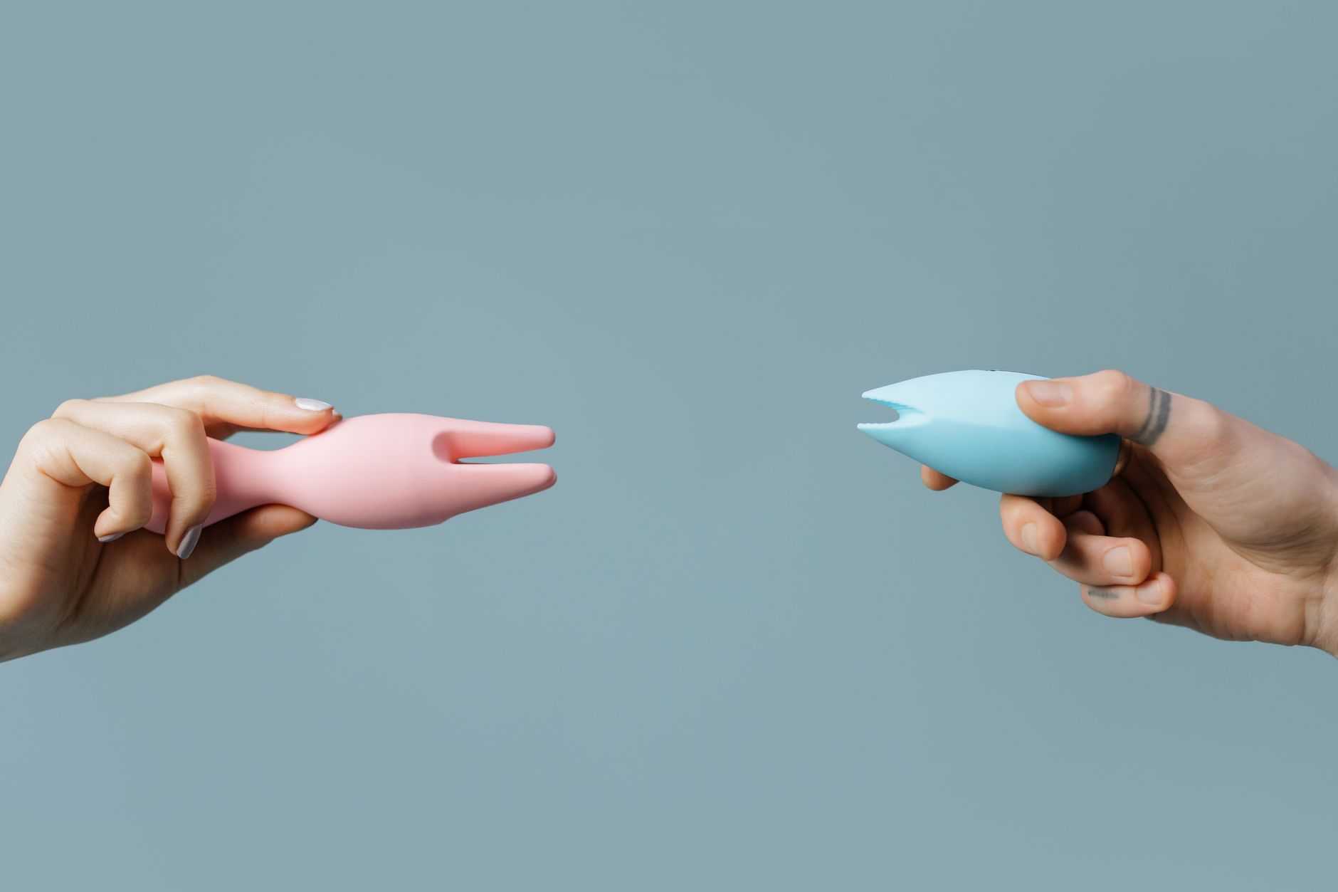 Mujer sosteniendo vibradores de silicona azul y rosa, representando la exploración consciente del placer después de los 40