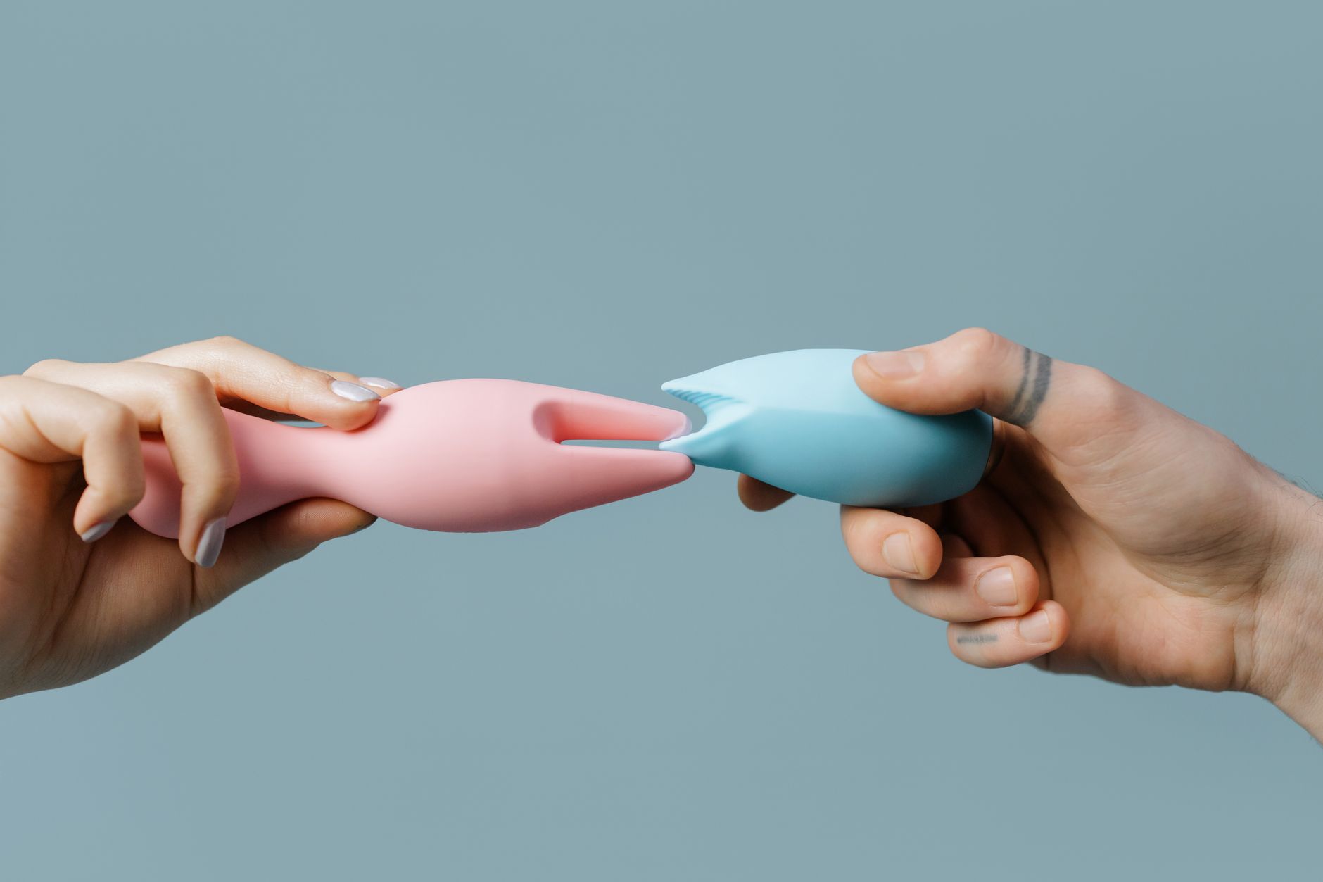 A colorful vibrator surrounded by flowers and citrus on a bright background, representing sensual pleasure and connection