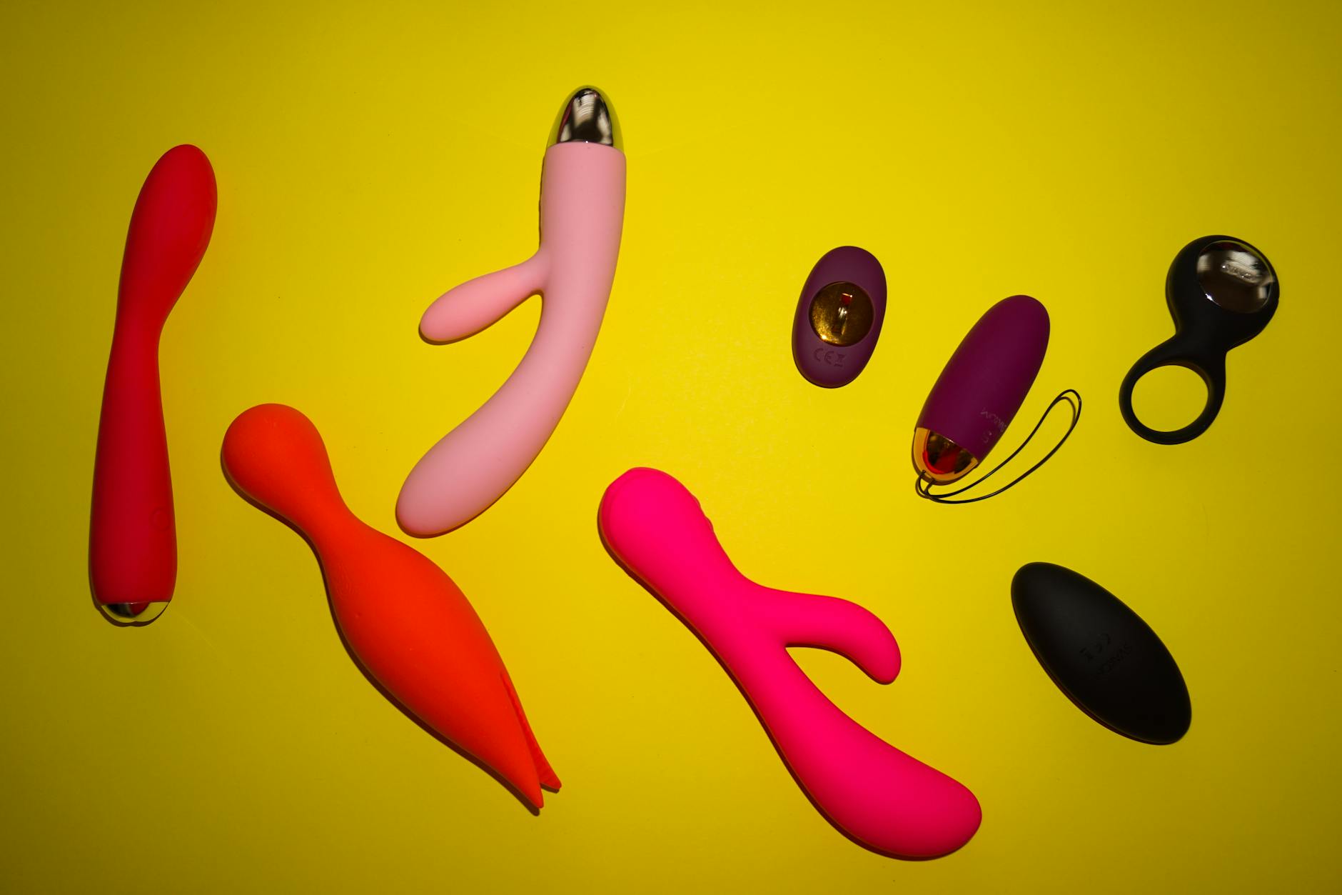 Colorful array of clitoral vibrators and lemon sexual toys displayed on a bright yellow background