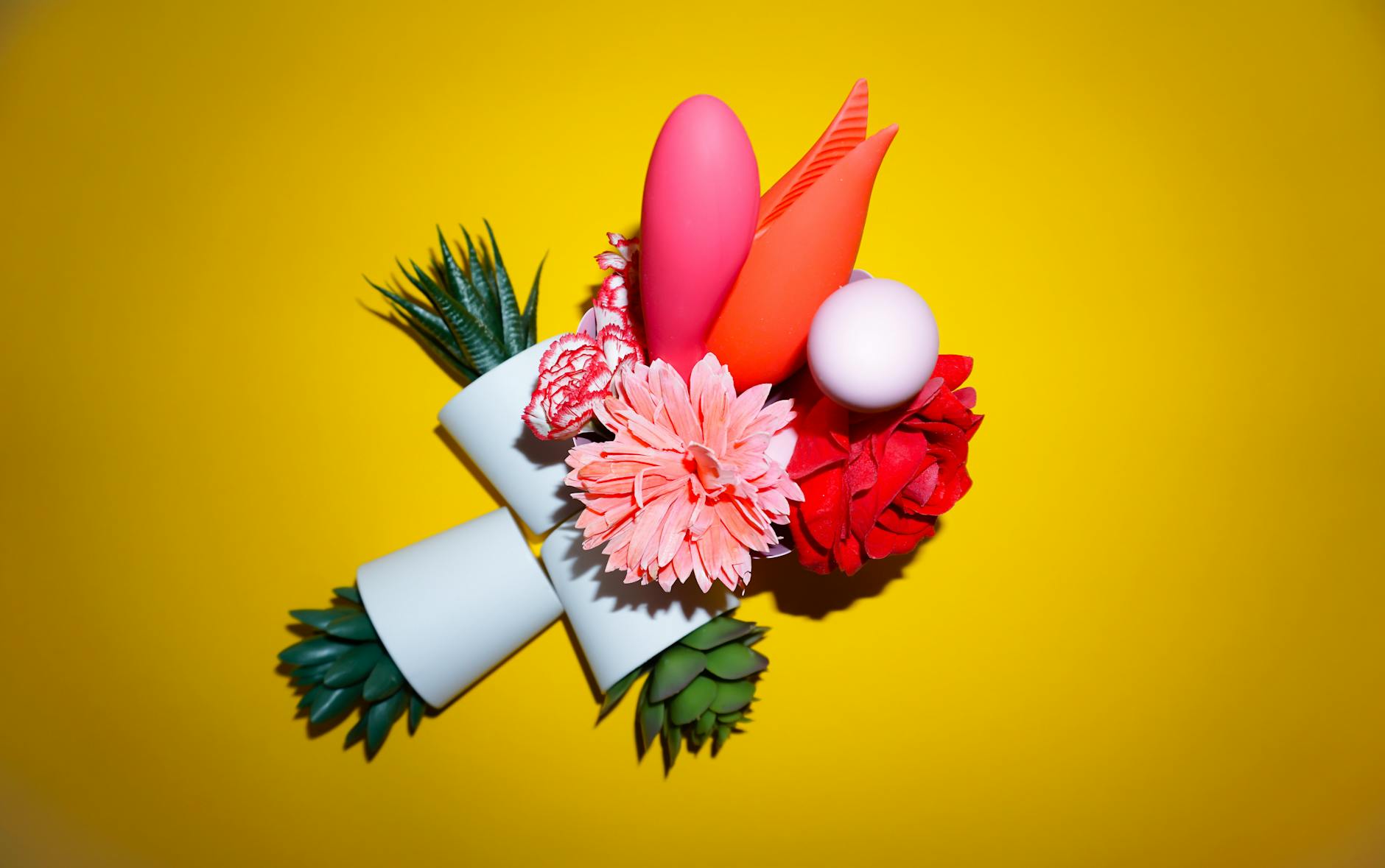 A hand holding an orange vibrator against a minimalistic purple backdrop, showcasing modern sensuality.